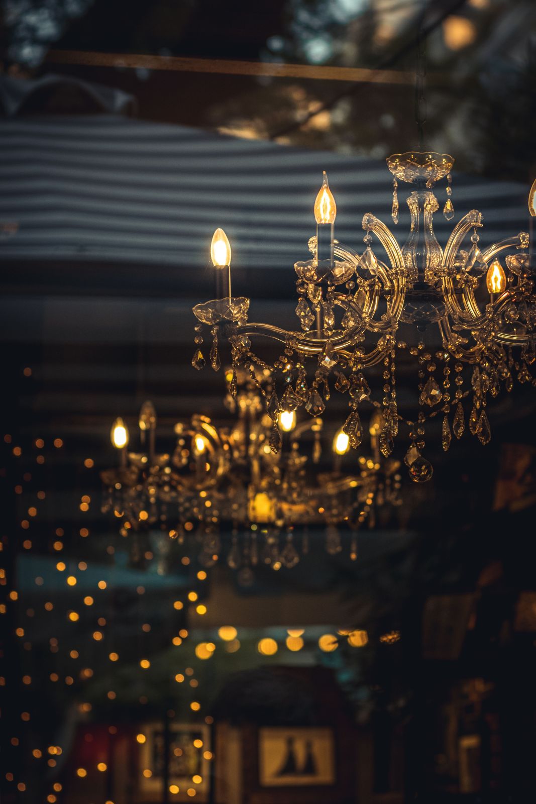 Candle-style chandelier glowing at twilight