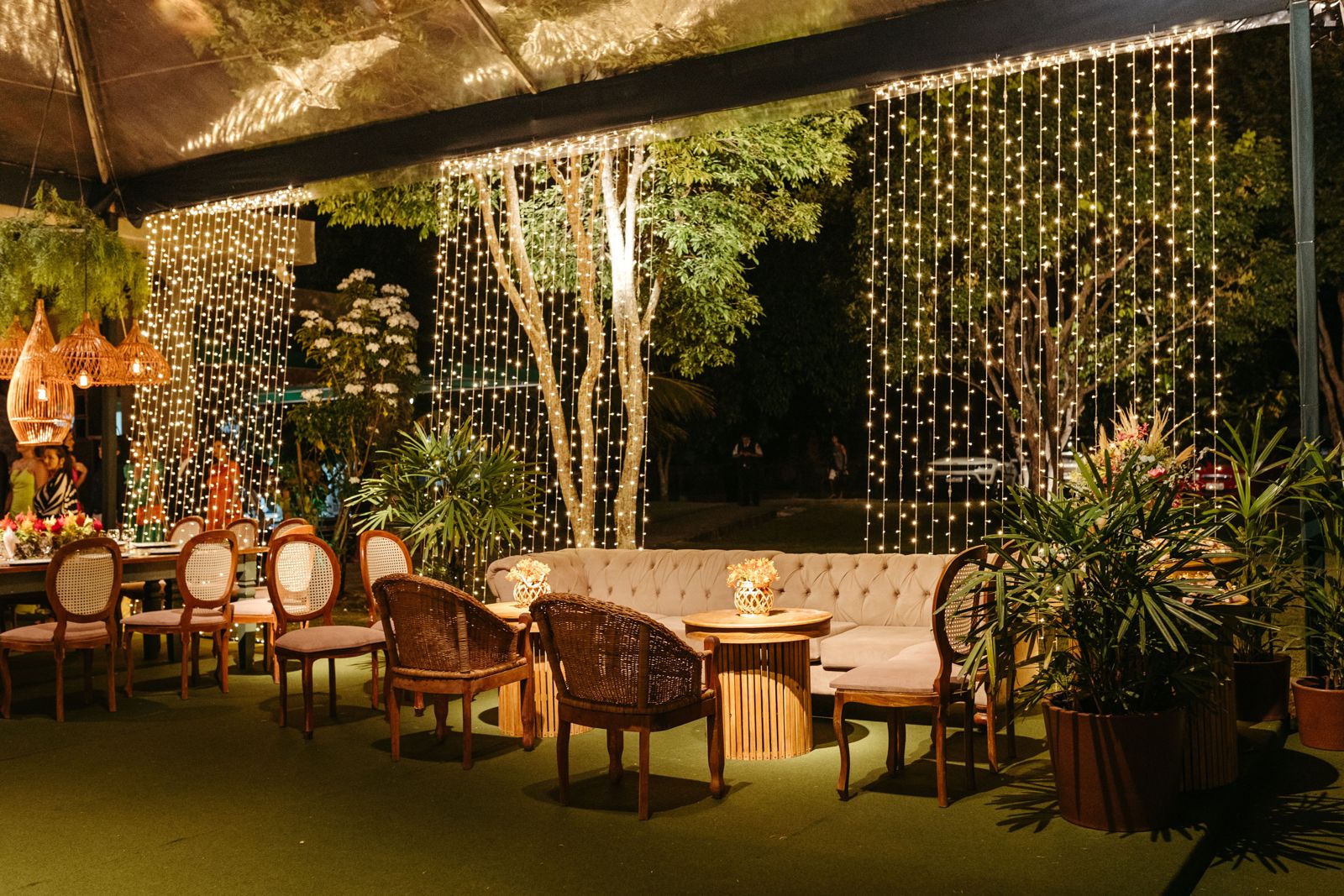 Patio lounge lit by curtain string lights at night